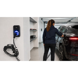 Conductrice branchant son véhicule électrique sur La Borne Bleue dans un garage